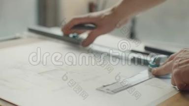 建筑师`办公桌：图纸，卷尺，直尺等绘图工具.. 工程师在明亮的办公室里画图纸